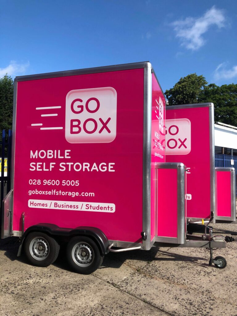 Bright pink mobile self-storage unit with the logo 