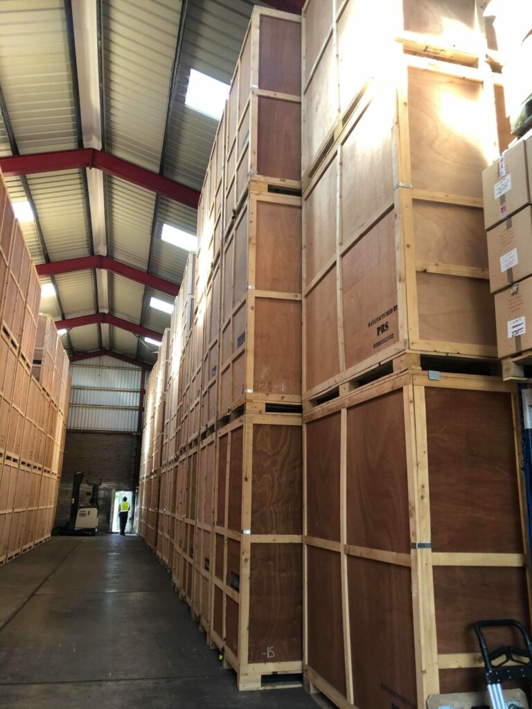 Tall stacks of wooden crates in a warehouse.