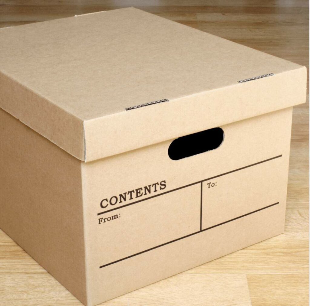 Cardboard moving box with labeled areas for contents and addressing details, ideal for offices and businesses, positioned on a wooden floor.
